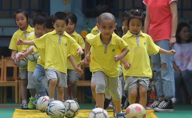 Học sinh Trung Quốc học cách chơi bóng. Ảnh: Xinhua