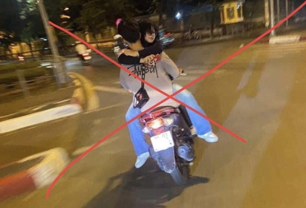 CSGT Hà Nội lập biên bản xử phạt thiếu niên bế bạn gái đi xe máy dạo phố trong đêm - Ảnh 1.