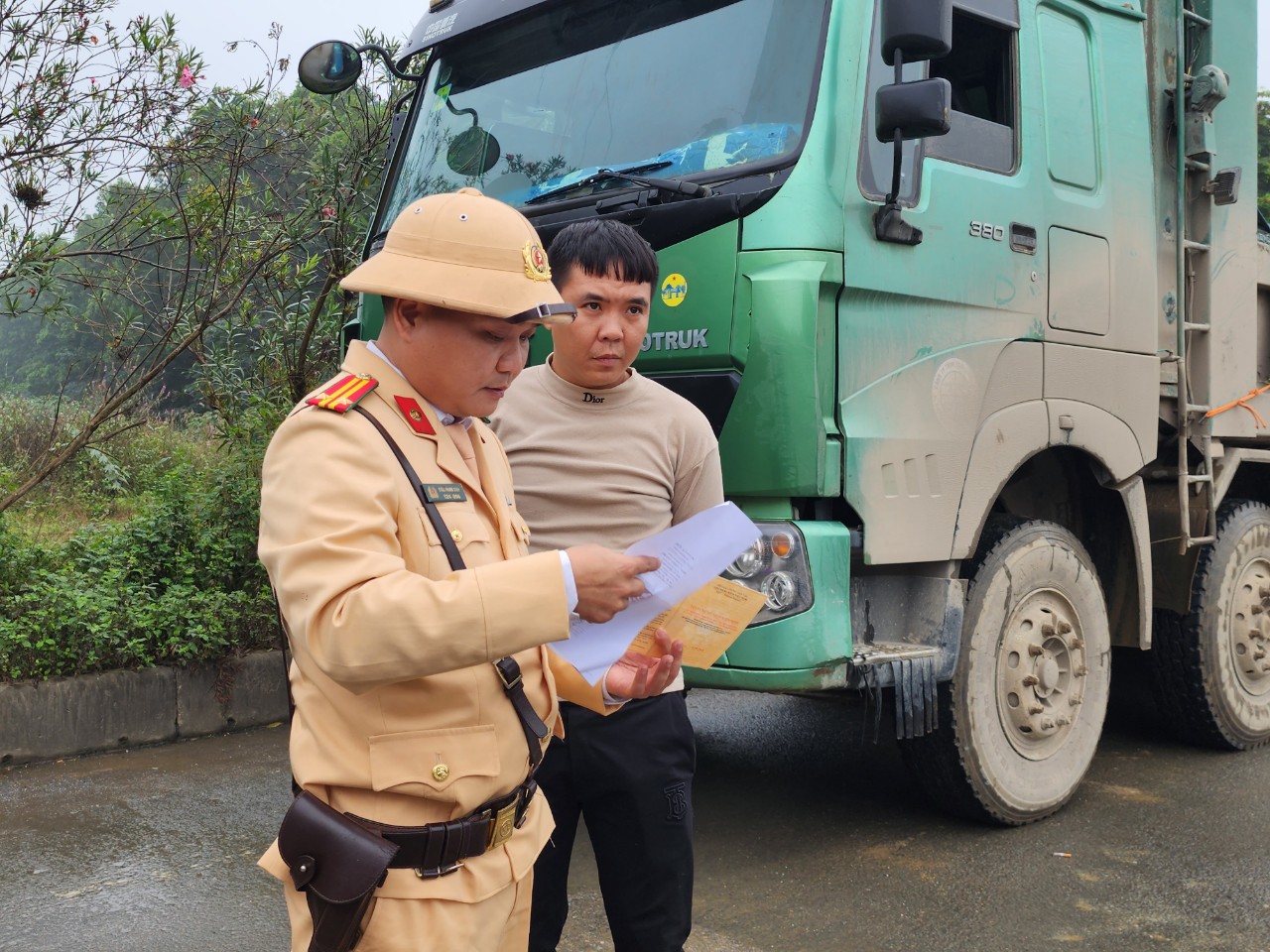 CSGT Hà Nội đội mưa cân tải trọng xe "hổ vồ" trên quốc lộ- Ảnh 1.