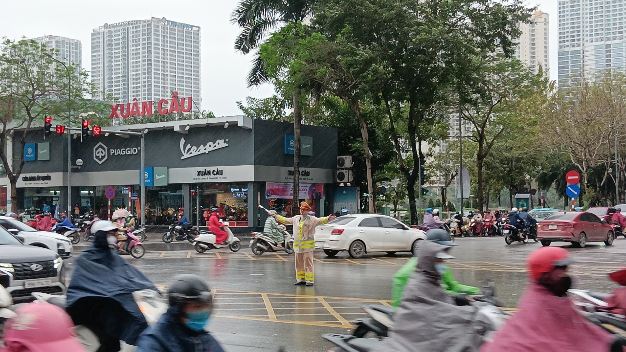 Đường phố Hà Nội ùn ứ, CSGT căng mình phân luồng dưới mưa- Ảnh 1.