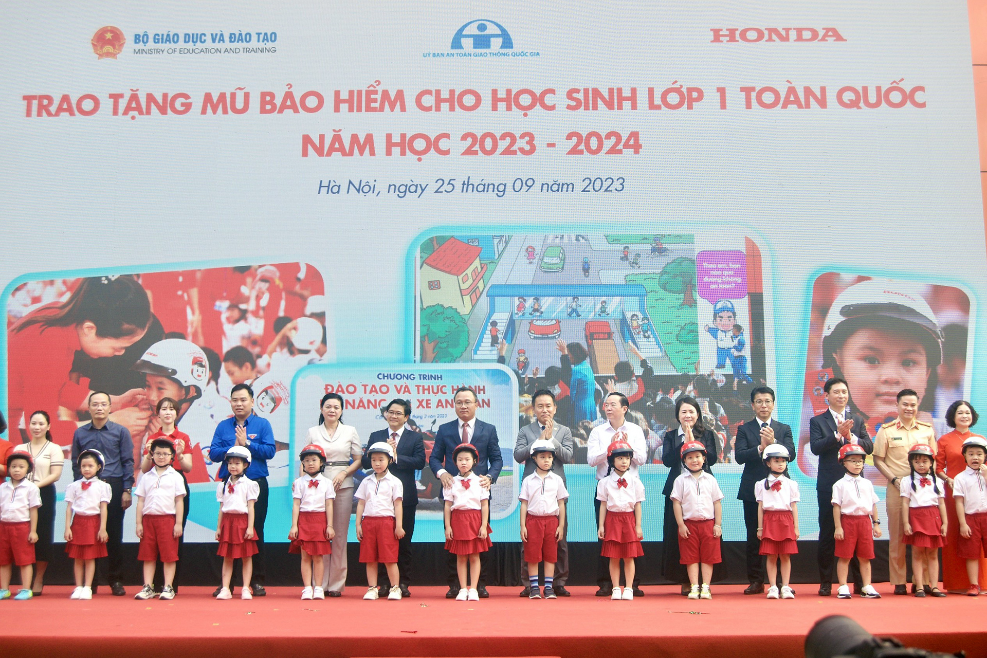 Các đại biểu trao tặng mũ bảo hiểm cho các em học sinh lớp Một trường Tiểu học Phú Đô, Hà Nội hồi tháng 9/2023.