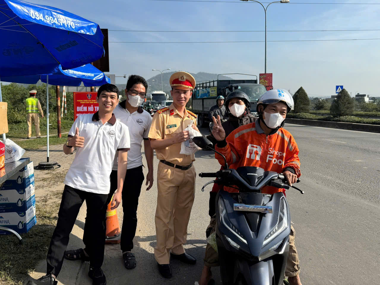 CSGT Đà Nẵng xuyên ngày, đêm hỗ trợ suất ăn, nước uống cho người dân về quê đón Tết- Ảnh 1.