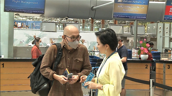 Đại diện Vietnam Airlines tại Singapore hướng dẫn một hành khách nước ngoài làm thủ tục lên tàu bay