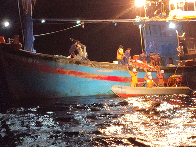 Lực lượng cứu nạn đưa thuyền viên gặp nạn từ tàu cá xuống xuồng cứu sinh để đưa lên tàu SAR 412