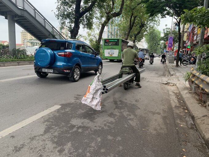 Xe máy kéo theo bó sắt dài cả chục mét trên phố Giảng Võ (quận Ba Đình).
