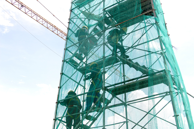 Công nhân di chuyển lên trụ tháp để thi công với độ cao hàng chục mét