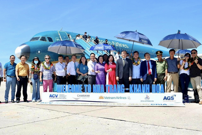Phó Chủ tịch thường trực UBND tỉnh Khánh Hòa ông Lê Hữu Hoàng và Đại diện các đơn vị chụp ảnh lưu niệm cùng các hành khách trên chuyến bay đầu tiên trên đường bay Singapore - Nha Trang