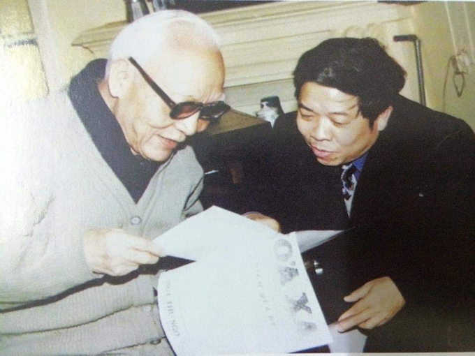 Ông Khuất Minh Trí - Chủ tịch Công đoàn Đường sắt Việt Nam cùng cụ Nguyễn Đăng (bên trái) xem lại tờ báo “Hỏa xa”