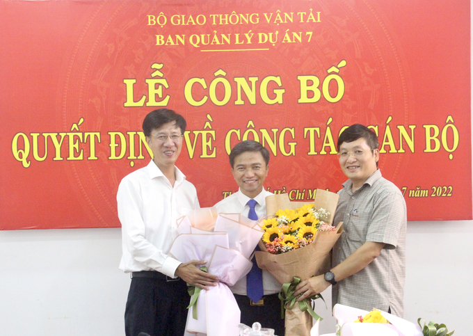 Ông Đinh Công Minh - Giám đốc Ban QLDA7 (bên trái) và ông Phạm Huy Hiếu - Phó Vụ trưởng Vụ Tài chính, Bộ GTVT (bên phải) tặng hoa chúc mừng ông Trần Đình Tuyên - Tân Phó Giám đốc Ban QLDA7