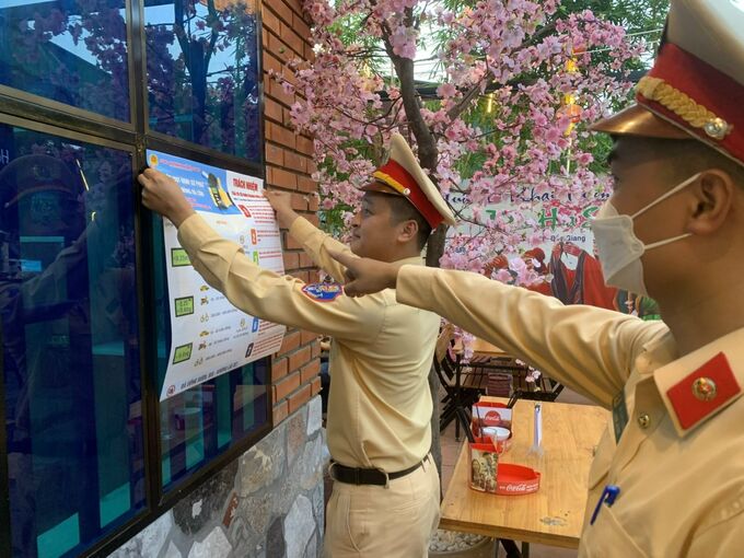 Lực lượng CSGT Công an TP.Bắc Giang dán tờ rơi cảnh báo về vi phạm nồng độ cồn khi tham gia giao thông tại các nhà hàng, quán ăn