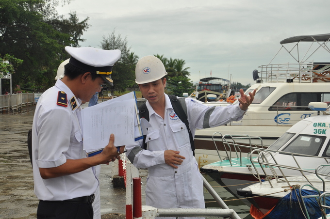 Thành viên Đoàn liên ngành trao đổi thực hiện nhiệm vụ kiểm tra tại bến đường thủy nội địa.
