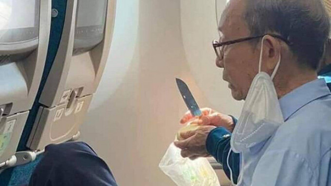 Hình ảnh vị khách lớn tuổi sử dụng dao gọt hoa quả trên khoang hành khách của máy bay