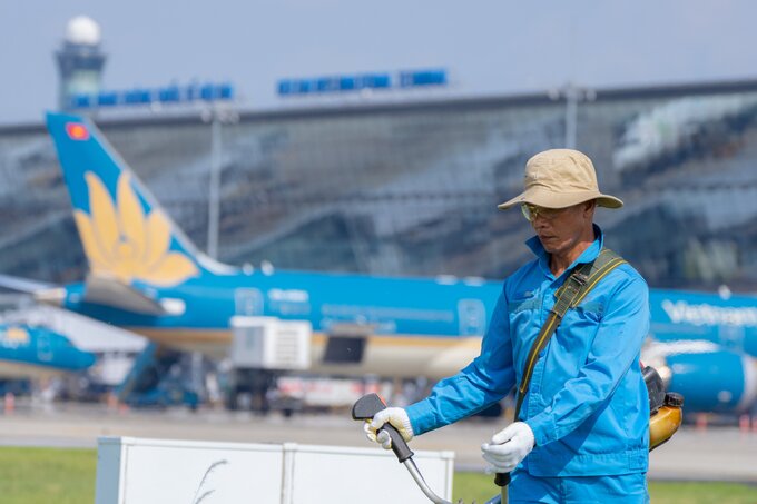 Người lao động Đội môi trường khu bay chạy đua với thời tiết để cắt cỏ, vệ sinh môi trường đảm bảo an toàn bay