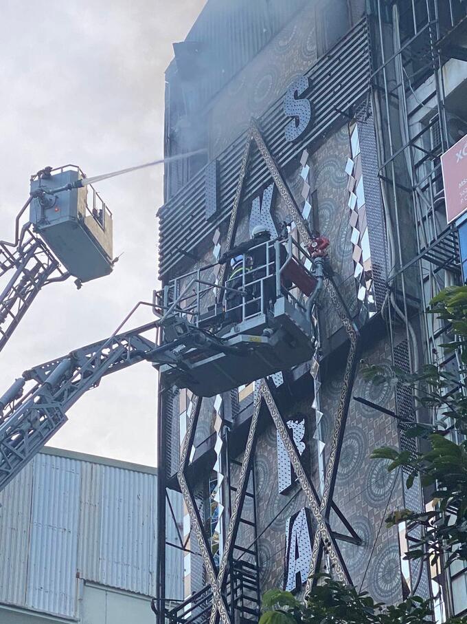 Cảnh sát PCCC và CHCN Công an quận Cầu Giấy bắc xe thang để khống chế đám cháy quán Karaoke tại địa bàn phường Quan Hoa.