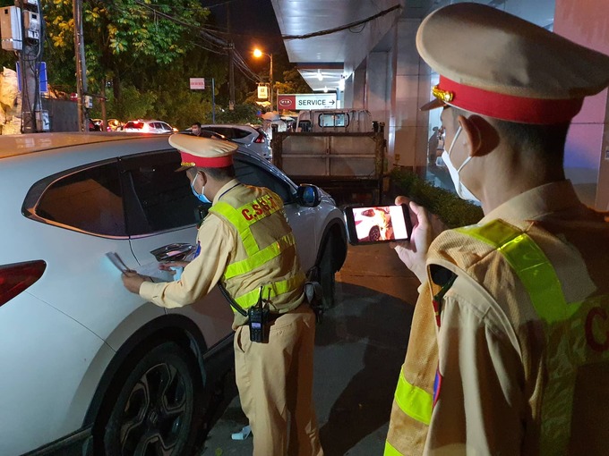 CSGT tiến hành dán niên phong tạm giữ ô tô do lái xe vi phạm nồng độ cồn tại đường Láng hướng Cầu Giấy, Hà Nội.