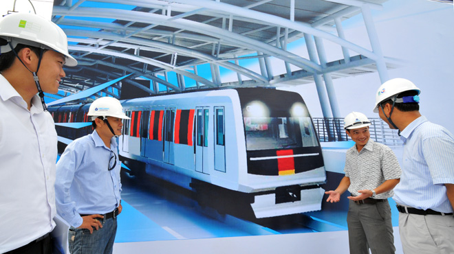 Các kỹ sư Việt Nam và Nhật Bản bên hình phối cảnh con tàu của tuyến đường sắt đô thị số 1 TP Hồ Chí Minh (Bến Thành - Suối Tiên). Ảnh Tuổi trẻ