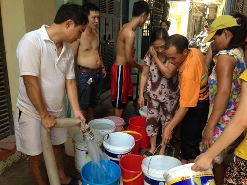 Người dân xếp xô lấy nước từ xe bồn tại ngõ 61 Ngu