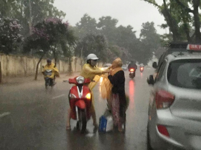 cô gái dừng xe mặc áo mưa cho bà cụ