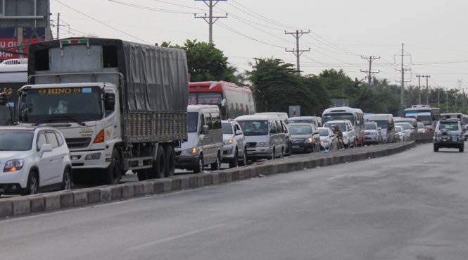 Xe cộ xếp hàng dài trên quốc lộ 1, đoạn qua tỉnh Tiền Giang để đi chuyển về hướng TP.HCM chiều 12-2 - Ảnh: Mậu Trường