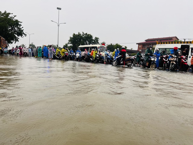 Nước lũ tràn qua quốc lộ 1 ở Quảng Nam, phương tiện qua lại khó khăn - Ảnh 2.