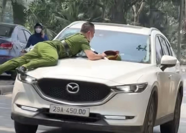 Bắt đối tượng hất công an lên nóc capo xe Mazda ở Hà Nội - Ảnh 1.