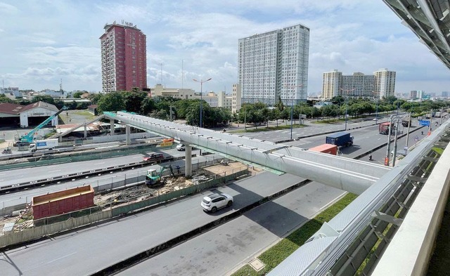 Hoàn thành lắp đặt nhịp dầm cuối cùng cầu bộ hành tuyến metro Bến Thành - Suối Tiên - Ảnh 1.