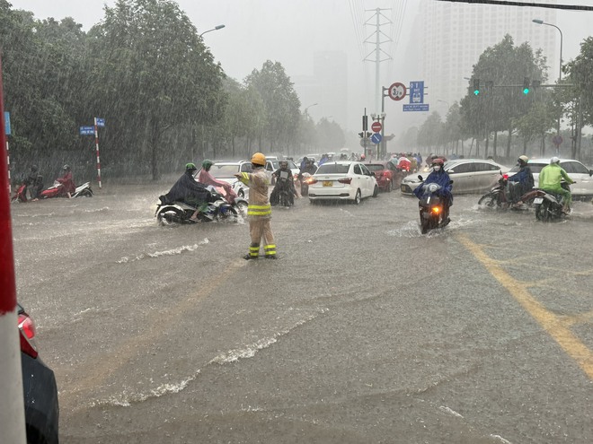 Cận cảnh nhiều tuyến đường Hà Nội ngập sâu sau mưa lớn, CSGT căng mình hướng dẫn giao thông- Ảnh 1.