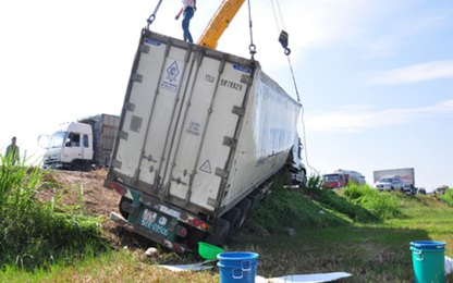 Mật ong tràn ruộng khi xe container lật, hai người kẹt trong cabin