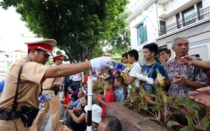 Cảnh sát giao thông tặng nước cho người dân xem diễu binh, diễu hành