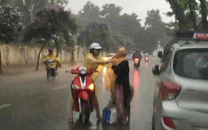 Tranh cãi quanh hành động cô gái dừng xe mặc áo mưa cho bà cụ