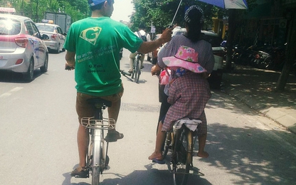 Hình ảnh đẹp ngày nắng nóng: Bố đạp xe che ô cho 2 mẹ con