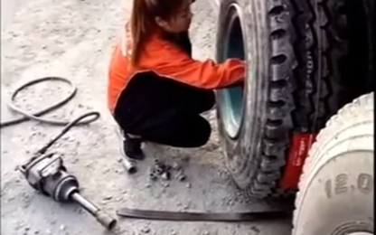 Cô gái trẻ tự thay lốp xe tải bằng tay