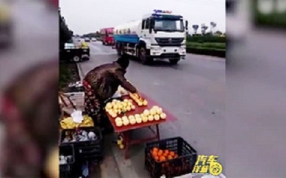 Xe rửa đường dừng phun nước khi qua chỗ người bán hoa quả