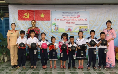 TP.HCM: Nữ CSGT tặng mũ bảo hiểm cho các cháu học sinh