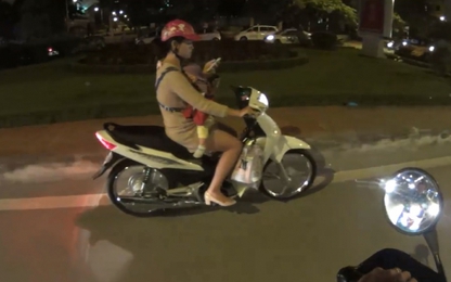 Địu trẻ trước ngực, người phụ nữ thản nhiên dùng ĐTDĐ khi lái xe