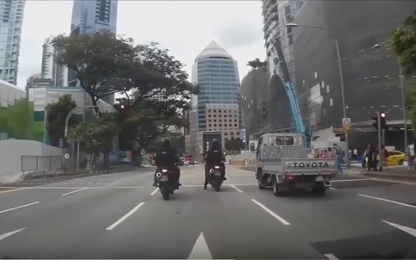 Cảnh sát đi môtô tự ngã xe khi dừng đèn đỏ