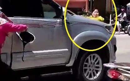 Người phụ nữ níu cửa xe, lê theo ôtô trên phố