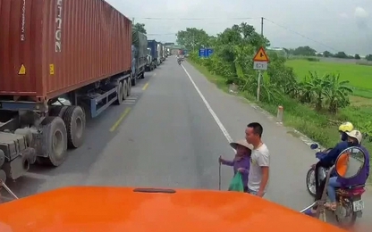 Tài xế container dừng xe dẫn bà lão sang đường