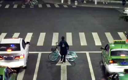Cô gái dựng xe đạp bảo vệ người say ngủ giữa đường