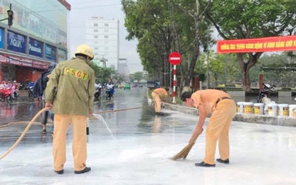 CSGT dầm mưa giúp người dân quét sơn bị đổ ra đường