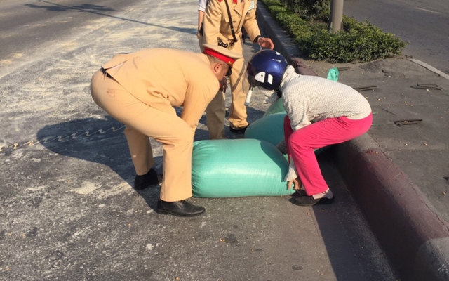 CSGT và người dân thu dọn 10 tấn ngô rơi vãi ra đường
